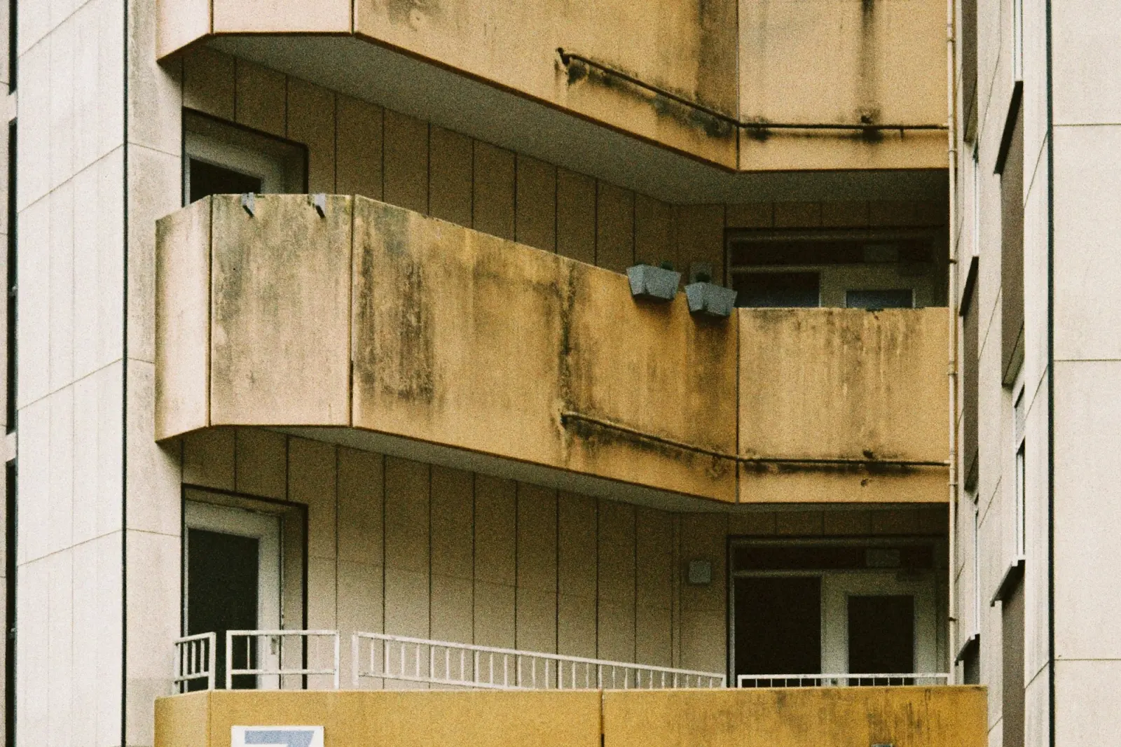 A modern residential tower with balconies against a clear sky